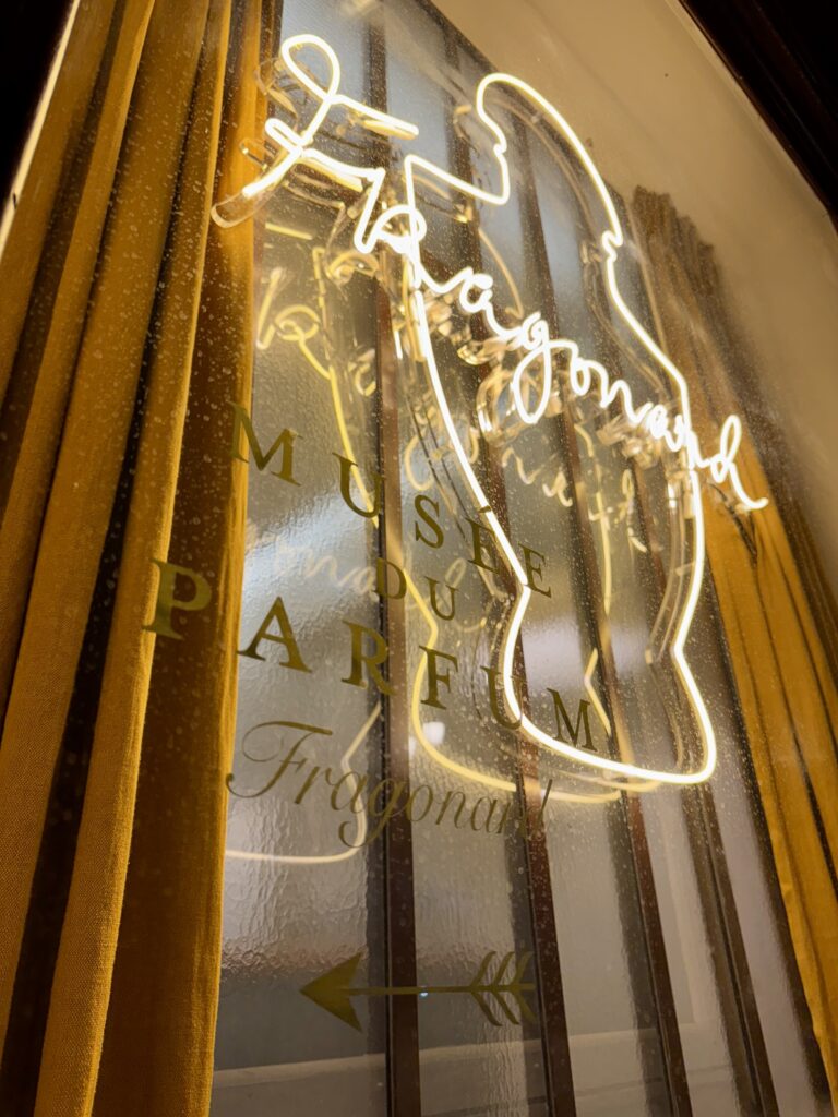 Gros plan détaillé de l'enseigne en néon verre traditionnel soufflé à la main pour le Musée du Parfum Fragonard, avec inscriptions "MUSEE DU PARFUM Fragonard GRASSE - PARIS".