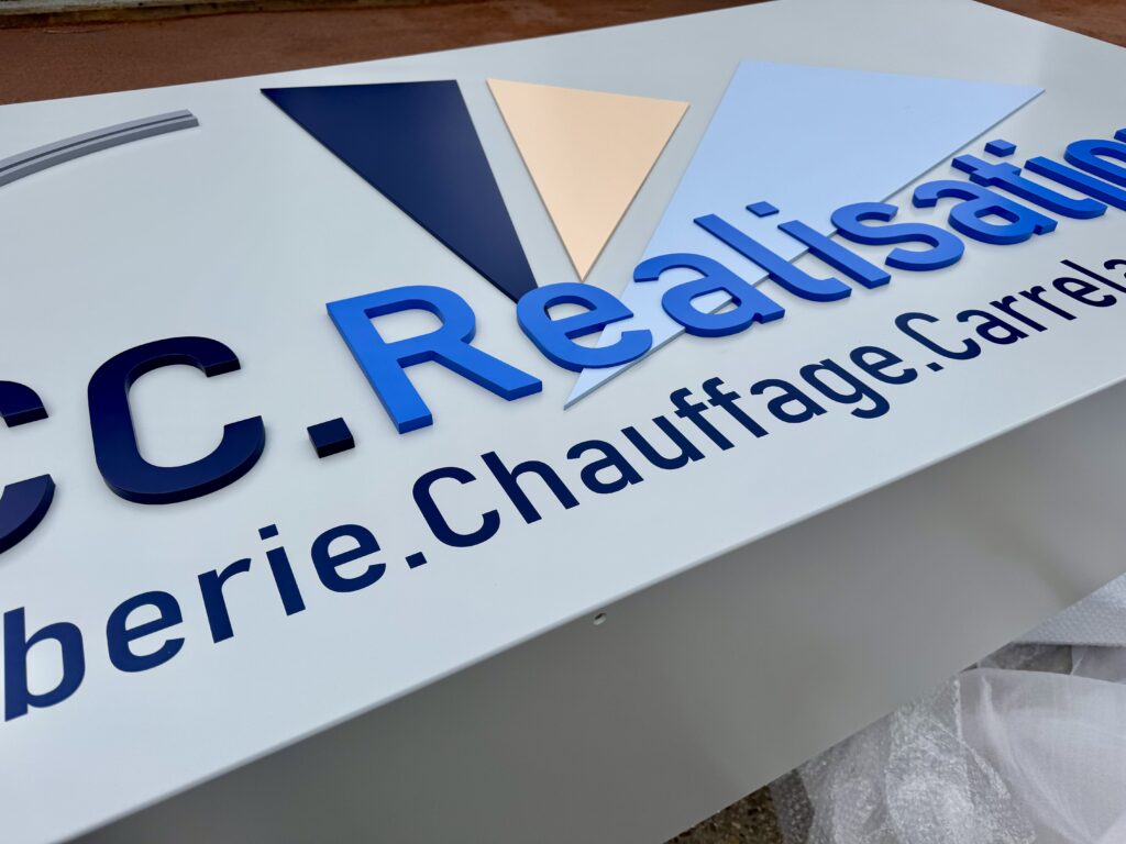 Enseigne en relief avec logo 3D sur façade en tôles peintes pour le siège de PCC Réalisation, conçue par CYGN & LUMEN.